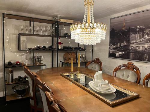 Un comedor con una mesa y una lámpara de araña. en Villa Rimppari 3mh 8hlö, en Oulu