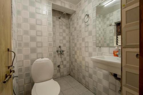 a bathroom with a toilet and a sink at 2 bhk apartment with paddy field view in Goa