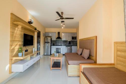 a living room with a couch and a kitchen at 2 bhk apartment with paddy field view in Goa