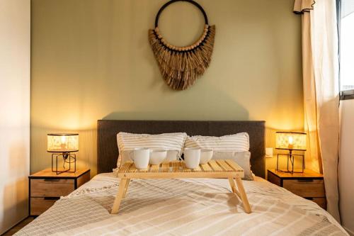 a bed with a tray with three white cups on it at Oasis T2 avec terrasse en bord de mer in Saint-Pierre