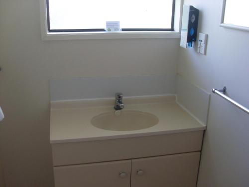 a bathroom with a sink and a window at Motel 22 in Lower Hutt