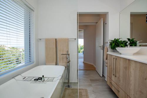 a bathroom with a tub and a sink at Eagles Nest in Knysna