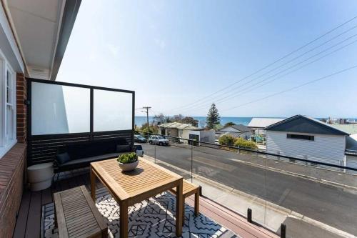 a balcony with a table and a view of a street at Burnie Retreat - Coastal Comfort Awaits in Burnie