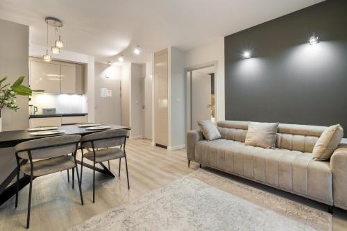 a living room with a couch and a table at RentPlanet - Apartamenty Zakopiańskie in Zakopane