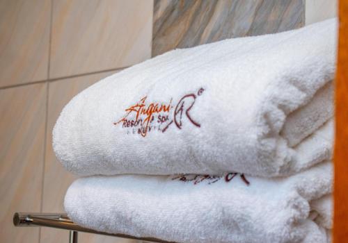 a pile of towels on a rack in a bathroom at Angani Resorts & Spa Limited in Shamenei