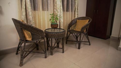 three chairs and a table with a potted plant on it at Ha Sharing in Shillong
