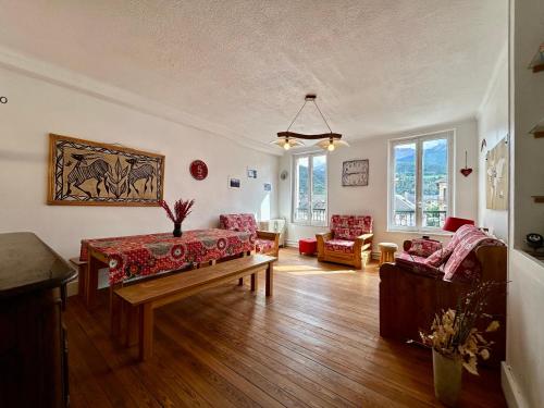 a living room with a couch and a table at Evasion Authentique - Centre ville - Jeux de société in Barcelonnette