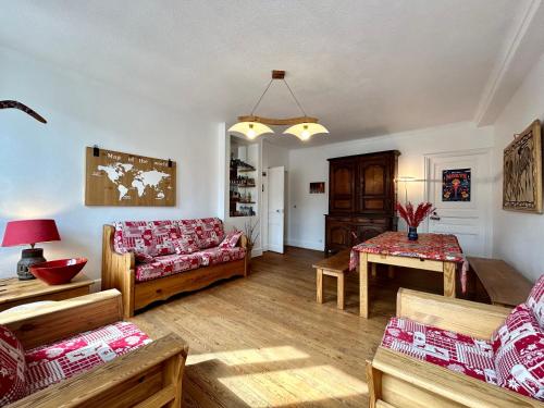 a living room with a couch and a table at Evasion Authentique - Centre ville - Jeux de société in Barcelonnette