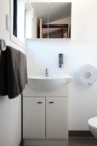 a white bathroom with a sink and a mirror at Gateway Motor Lodge - Wanganui in Whanganui