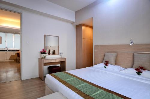 a bedroom with a large white bed and a desk at One-Stop Residence & Hotel in Kuala Lumpur