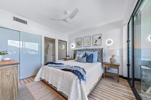 a bedroom with a bed with blue pillows at Airlie Breezes at the Boathouse in Airlie Beach