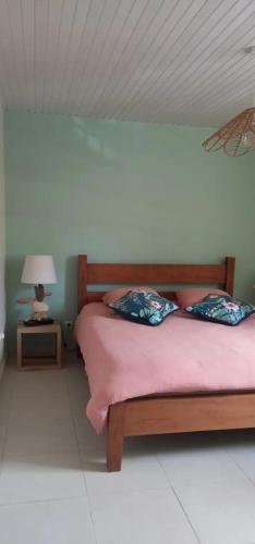 a bedroom with a bed and a lamp on a table at L'appartement de la plage in Le Diamant