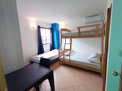 モンタニタにあるHostal Yaku Montañitaの小さな客室で、二段ベッド2台、テーブルが備わります。