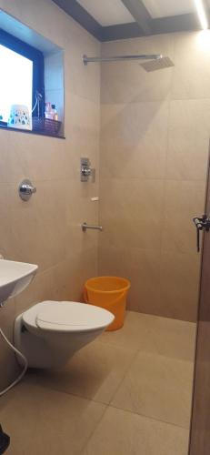 een badkamer met toilet en glazen douche bij Homestay DGH in Alleppey
