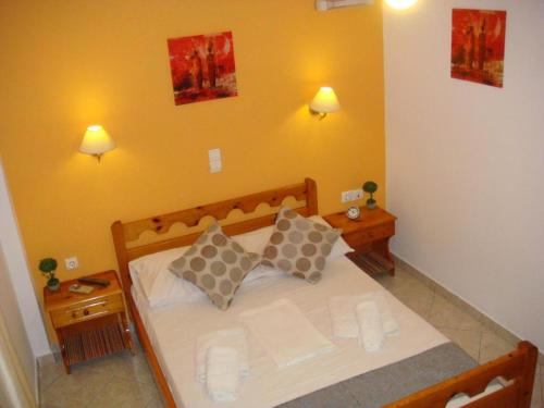 a bedroom with a bed with two pillows on it at Boussetil Rooms CapAnMat in Tinos Town