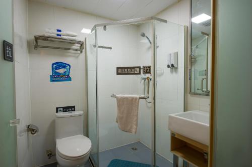 uma casa de banho com um chuveiro, um WC e um lavatório. em 7Days Premium Harbin Heping Road Provincial Government em Harbin