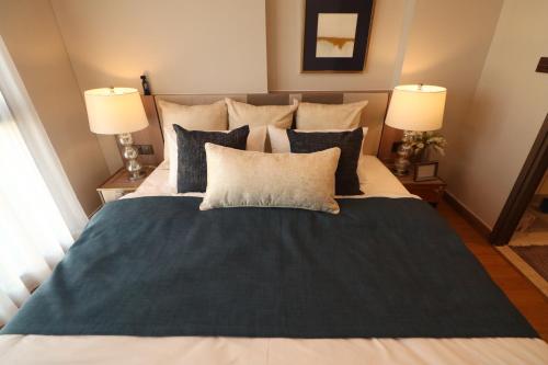 Un dormitorio con una cama grande con dos lámparas. en Astra Sky River HOC, en Chiang Mai