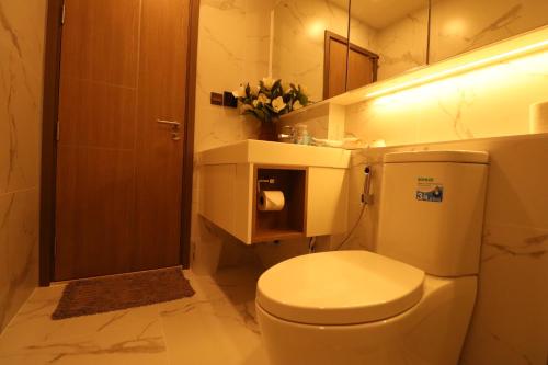 Un baño con un inodoro blanco y un lavabo. en Astra Sky River HOC, en Chiang Mai