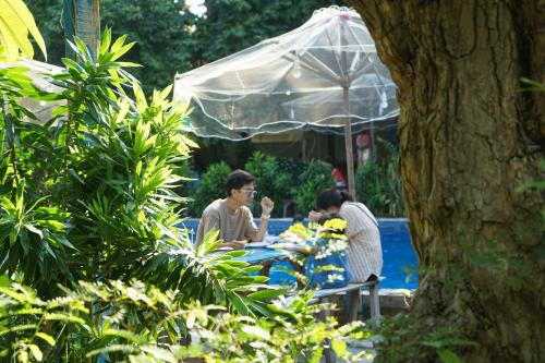 two people sitting at a table under an umbrella at Stop And Go Làng Chài Bàu Trắng in Ấp Thiẹn Ái