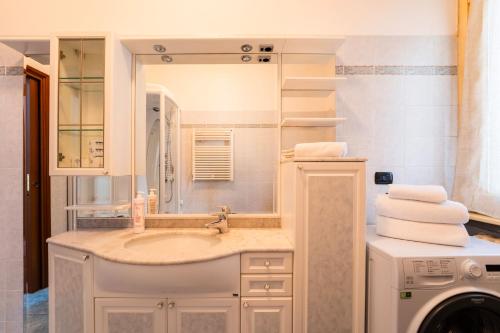 a bathroom with a sink and a washing machine at Spring Apartment by Wonderful Italy in Como