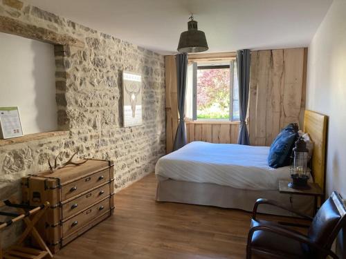 une chambre avec un lit, une commode et une fenêtre dans l'établissement Gîte 5 chambres piscine vue montagne, à Ordonnaz