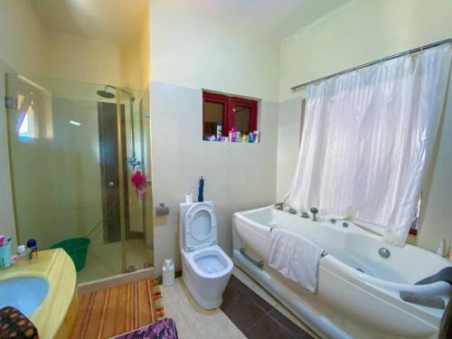 a bathroom with a tub and a toilet and a sink at Two Bedroom Apartment in Mombasa