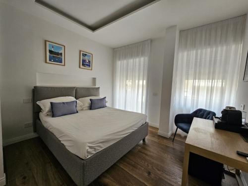 a bedroom with a bed with blue pillows and a desk at Be Your Home - Riviera Suites in Civitavecchia