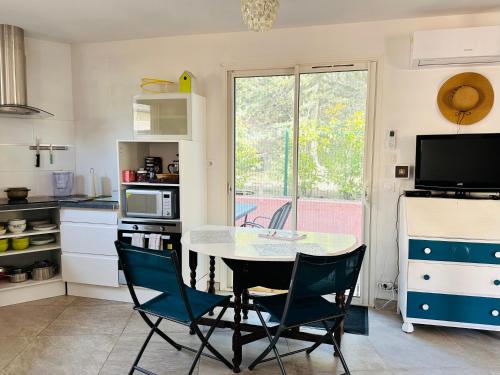 Il comprend une cuisine avec une table et des chaises ainsi qu'une télévision. dans l'établissement Moderne Mini Maison - Quartier Résidentiel Calme, à Lézignan-Corbières