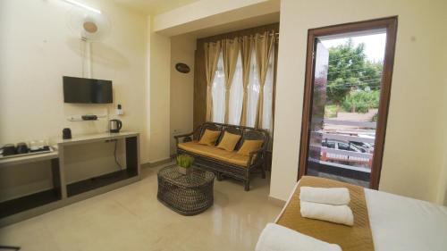 a room with a bed and a couch and a window at Ha Sharing in Shillong