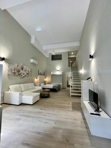 a living room with white furniture and a staircase at Ribera Suites GP in Córdoba