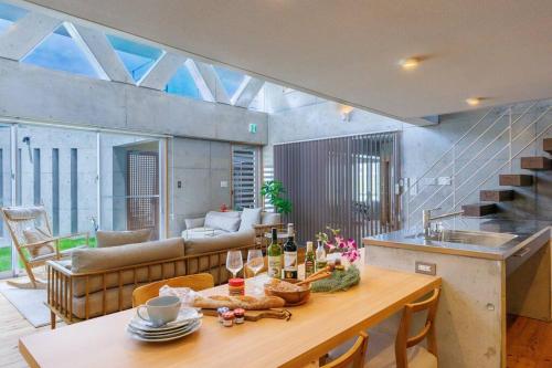 a kitchen and living room with a table and a couch at 沖縄市コザ サウナ付きBBQ可能 最大14名 飲食店多数 GBs house in Goya