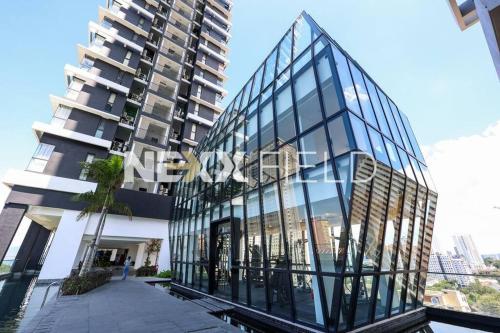 a glass building next to a tall building at Urban Suites Penang by Nexx Field in Jelutong