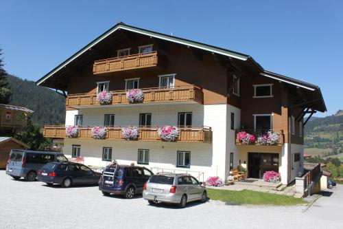 a large building with cars parked in a parking lot at Apartment Panorama in Wagrain