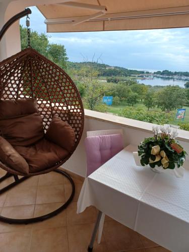 a room with a chair and a table and a window at Room Pometo III in Poreč