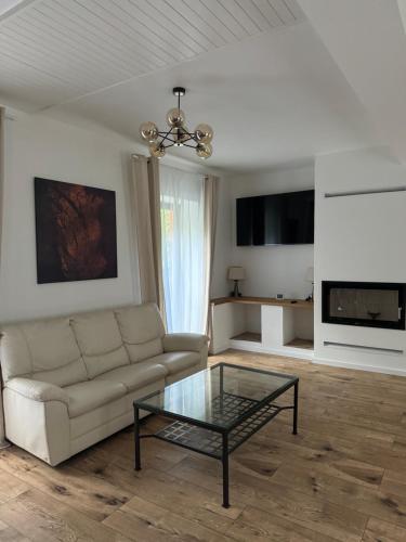 a living room with a couch and a glass table at Tkalcovna U Zlatého potoka in Dobřany