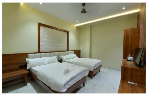 a bedroom with two beds and a television in it at Yashvrinda in Mandor