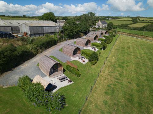an overhead view of a row of buildings with trees at Grassington Farm by Wigwam Holidays in Helston