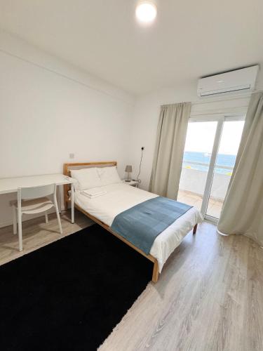 a bedroom with a bed and a desk and a window at Sea view 3 bedrooms apartment in Limassol