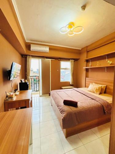 a large bedroom with a large bed and a desk at Room Transit 3jam Apartemen Margonda Residence 2 By Younz Apartemen in Pondokcina