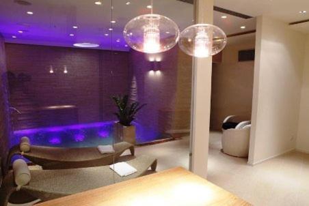 HR Hotel & Spa في بيانو دي سورينتو: غرفة معيشة مع إضاءة أرجوانية وأريكة