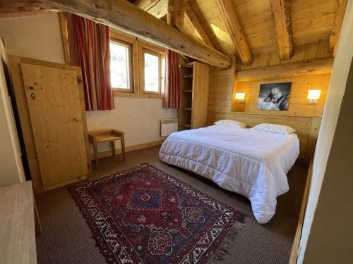 une chambre avec un lit dans une cabane en bois dans l'établissement Cortina - 52 - Appart lumineux - 8 pers, à Les Deux Alpes