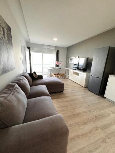a living room with a couch and a kitchen at Sea view 3 bedrooms apartment in Limassol
