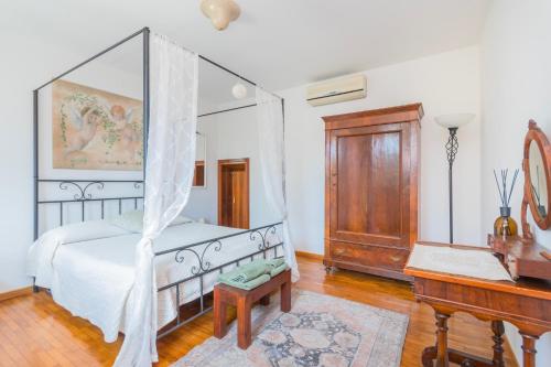 a bedroom with a canopy bed and a piano at Traghetto vecchio house in Cavallino-Treporti