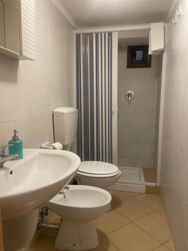 a bathroom with a white toilet and a sink at dimora cieli di dante 17 in Polignano a Mare