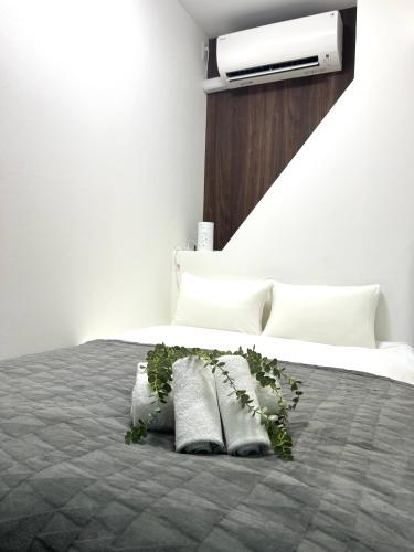 a bedroom with a bed with pillows and a plant at Ikebukuro Area R1 NishiikeApartment 5F No Elevator in Tokyo