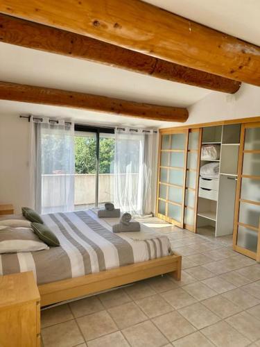 une chambre avec un grand lit et une fenêtre dans l'établissement Villa Family - Clim, Piscine & Pétanque, à Pourrières