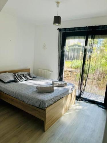 une chambre avec un grand lit et une grande fenêtre dans l'établissement Villa Family - Clim, Piscine & Pétanque, à Pourrières