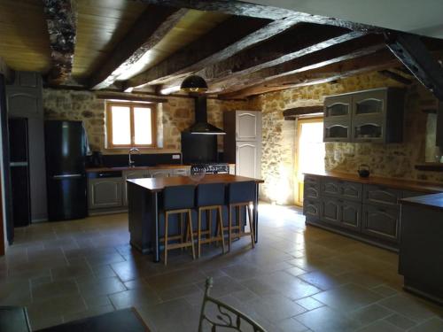 - une cuisine avec un îlot au milieu d'une pièce dans l'établissement Gîte des 3 pays, entre Corrèze,Dordogne et Lot, à Cublac