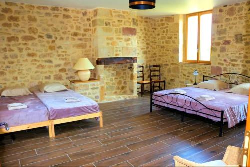 Cette chambre comprend 2 lits et une cheminée. dans l'établissement Gîte des 3 pays, entre Corrèze,Dordogne et Lot, à Cublac