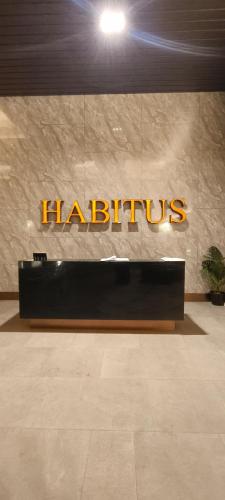 a hotel lobby with a harittilus sign on a wall at HABITUS Elmina Denai Alam in Shah Alam